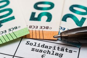 Schriftzug Solidaritätszuschlag und Geldscheine